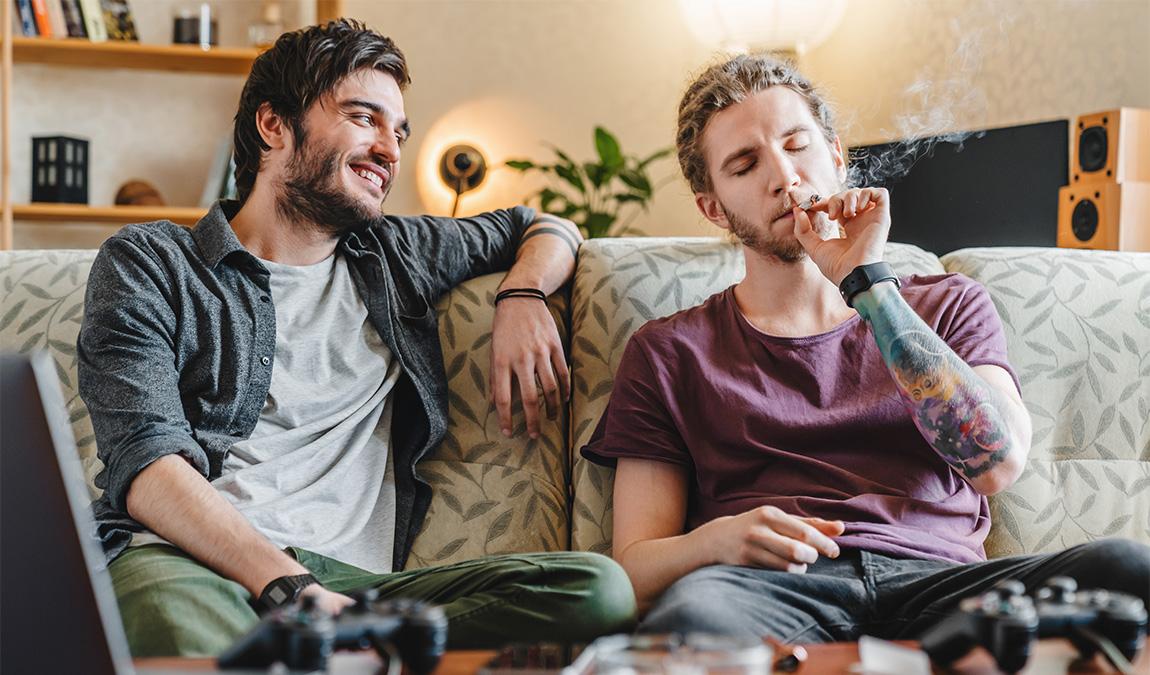 Two men relaxing on a couch after buying THCa prerolls online near Dallas, Texas.